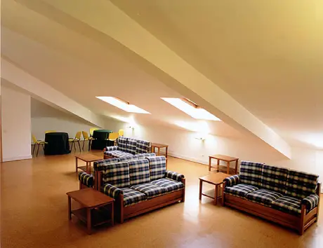 Sala de convívio da residência de estudantes em Lisboa da FCL. Com 3 sofás nas imagem e mesas de apoio.
